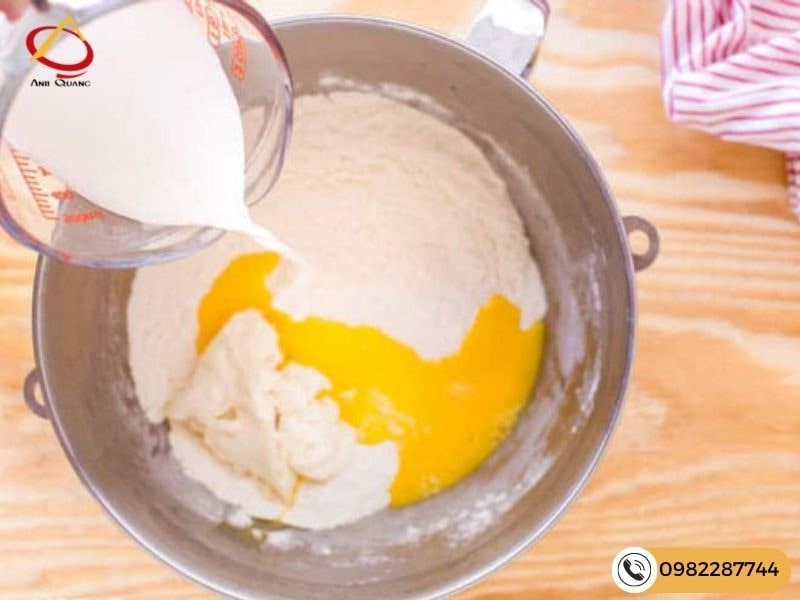 Bước 2 - Thêm sữa tươi, bơ chảy, trứng vào hỗn hợp bột và trộn đều